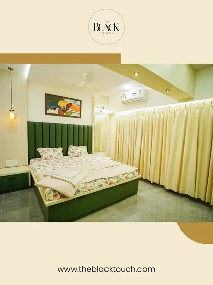 Another view of the green-themed bedroom, showing the full-length curtains and simple, modern furniture. The pendant light adds a touch of contemporary style to the serene space.