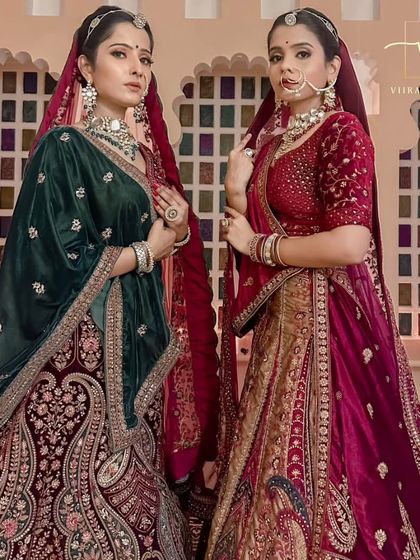 A close-up of two brides, highlighting the detailed craftsmanship of the velvet dupattas and the stunning bridal jewelry that can be rented to complete the look.