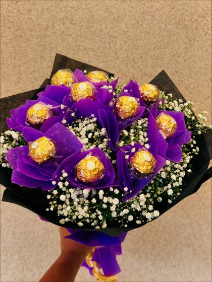 A slightly different angle of the purple Ferrero Rocher bouquet, emphasizing its depth and the generous amount of chocolates and flowers.