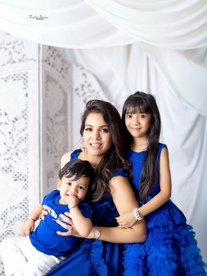 A beautiful portrait of a mother with her two children. The coordinating royal blue outfits look stunning against the clean white backdrop.