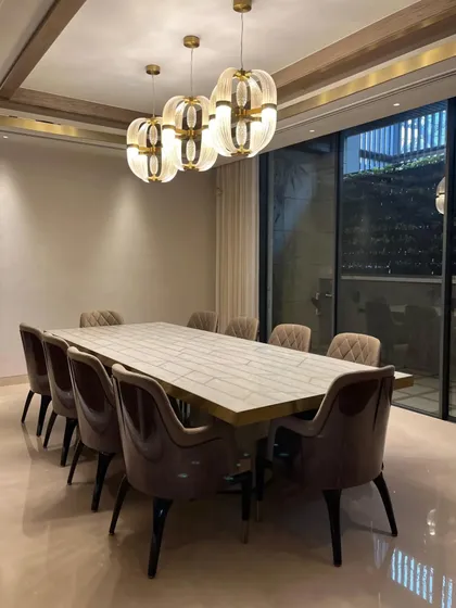 The reflection in the window shows how the statement lighting is a key feature, designed to be admired from both inside and out. It is a perfect example of dining in style.