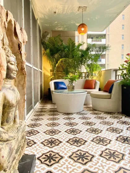 For this balcony makeover, we used bold, patterned floor tiles to create a strong design statement. The space is anchored by a serene Buddha sculpture and surrounded by tall areca palms, creating a tranquil, resort-like feel right at home.