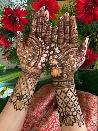 Both hands together, showing the complete lotus and peacock design.