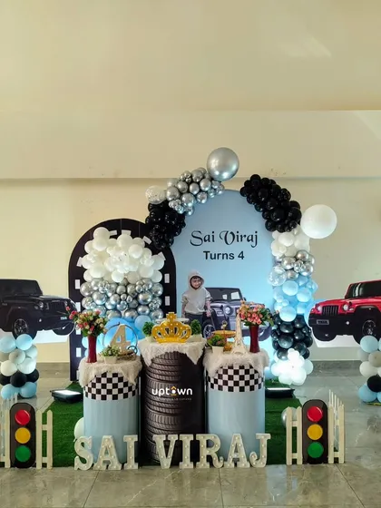 I create unique, personalized themes for birthdays, like this exciting Thar jeep setup for a 4th birthday. It includes custom vehicle cutouts, a tire-themed pedestal, and a color-coordinated balloon arch for any young car enthusiast.