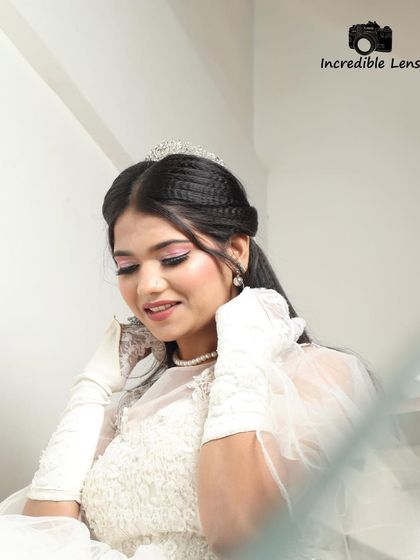 A beautiful, soft-lit portrait. This angle highlights the delicate tiara and the crimped texture in the hair, adding a modern touch to the classic look.