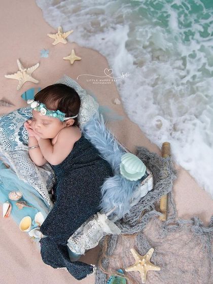 A mermaid dreaming by the ocean's edge. This overhead shot beautifully captures the details of the theme, from the shimmering tail to the starfish and shells scattered on the sand.
