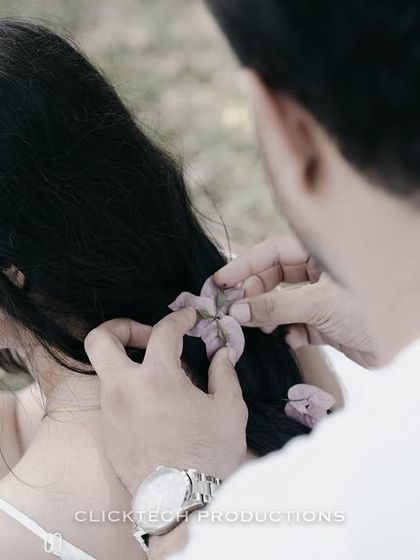 A tender close-up of the groom placing a flower in the bride's hair, a small, intimate detail from their Coorg photoshoot.