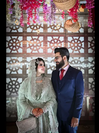 A candid moment captured during a formal portrait session. The genuine look shared between the bride and groom adds a layer of warmth and authenticity to the photo.