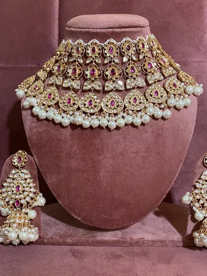 A different style of modern choker with ruby stones and larger pearl drops. This rental set comes with statement earrings.
