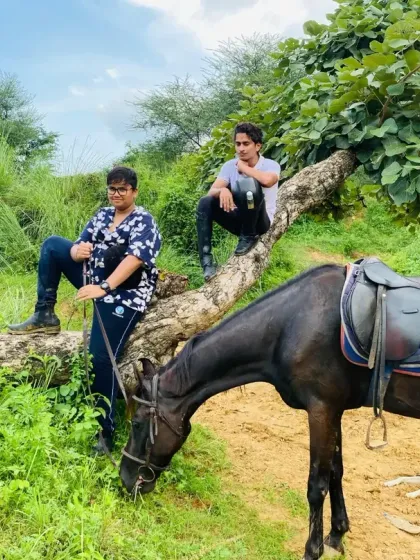 Taking a break on the trail. Here, riders relax on a fallen log while their horses graze peacefully nearby, showing the relaxed and flexible nature of our guided tours.