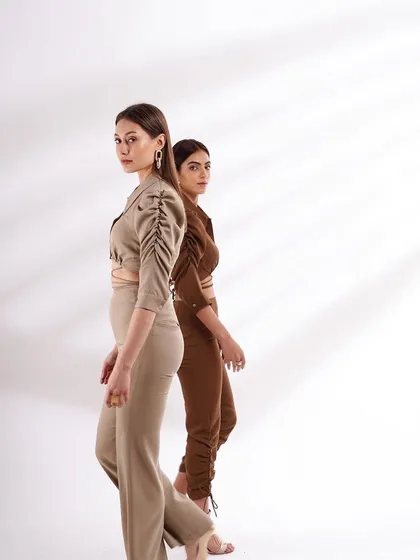A dynamic shot of two models in neutral-toned co-ord sets. The back-to-back pose creates a sense of movement and is perfect for a modern e-commerce gallery.