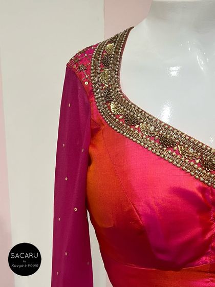 A close-up of the elaborate hand embroidery on a pink blouse, featuring antique gold sequins and beadwork.