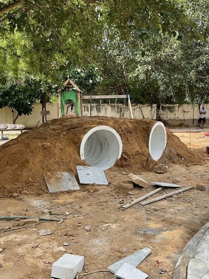 A children's play tunnel under construction at a school landscape project. We incorporate playful, custom-built features into our designs for educational institutions.