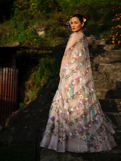 A breathtaking shot in the mountains for Baavli. The model, dressed in a floral lehenga, looks like a part of the landscape, creating a truly magical fashion portrait.