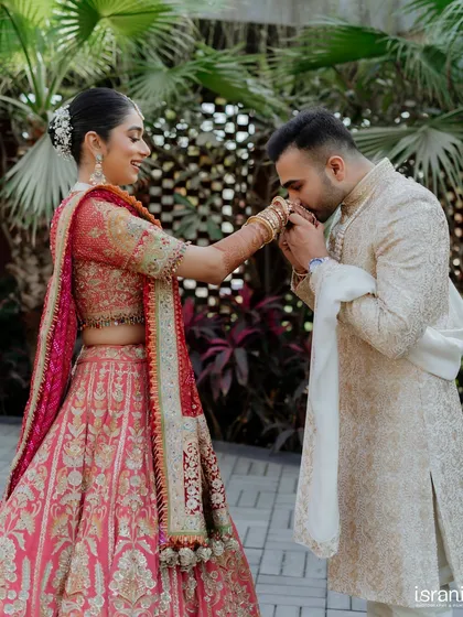 The groom gently kisses his bride's hand, a timeless gesture of love and respect captured beautifully.