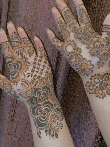 Two different styles on two hands, one with spaced-out motifs and the other with denser patterns.