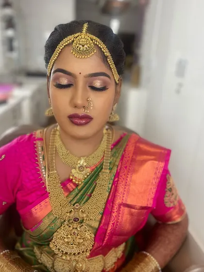 A close-up of Lakshmi Priya's Muhurtham makeup, with her eyes closed to show the beautiful gold and pink shimmer eyeshadow. This look was created to complement her vibrant pink and green saree.