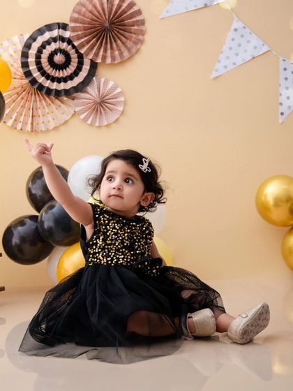 Pointing to the sky, this little adventurer is ready for her next journey in this charming hot-air-balloon-themed shoot.