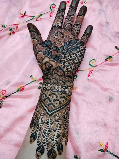 This design features a beautiful chevron pattern on the wrist that flows into a dense, leaf-like pattern on the back of the hand.