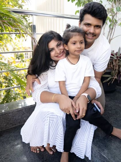 A warm and loving family portrait taken outdoors. The natural setting and their close embrace create a feeling of comfort and connection.