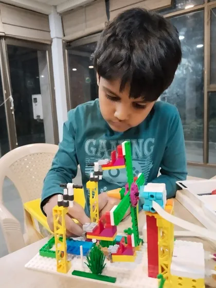 A student carefully constructs his LEGO project, a fun park complete with a Ferris wheel. My classes encourage attention to detail and creative problem-solving.