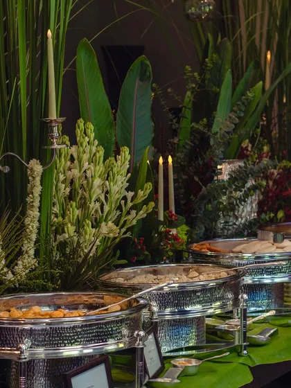 Another angle of the elegant buffet setup, highlighting the silver candelabras and lush greenery that create a sophisticated and timeless look for a large dinner party.
