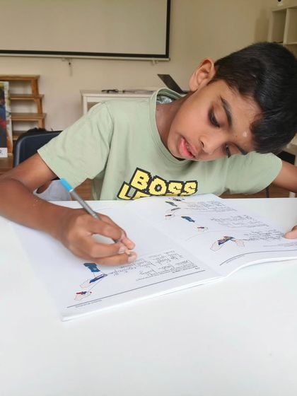 It's not just about building; it's about understanding the principles behind the build. A student takes notes and sketches in his workbook during our LEGO Education summer camp.