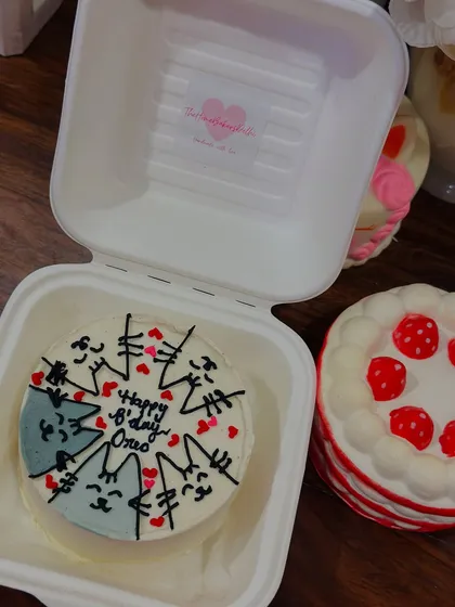 A sweet little scene with two bento cakes. One features a circle of cute cats for a birthday, and the other is a lovely strawberry design, showing the variety we can create.