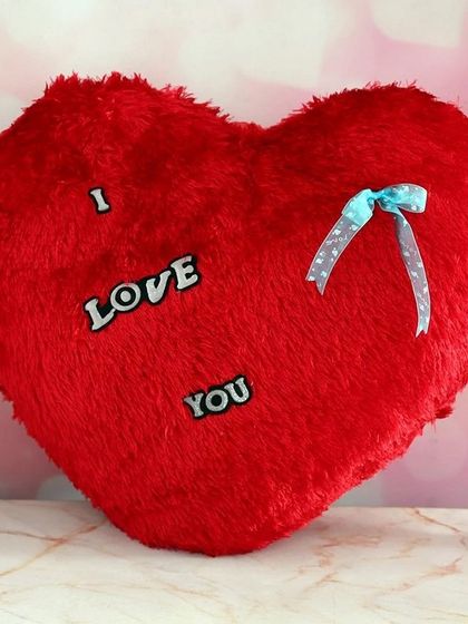 A classic red, fluffy, heart-shaped cushion with the words "I Love You." This soft toy makes for a timeless romantic gesture for Valentine's Day or an anniversary.