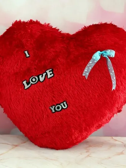 A classic red, fluffy, heart-shaped cushion with the words "I Love You." This soft toy makes for a timeless romantic gesture for Valentine's Day or an anniversary.
