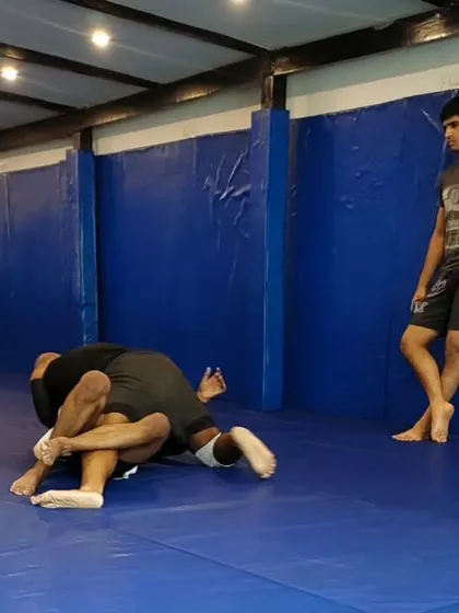 A student working to pass the guard during a live roll. This is where you put your technique to the test.