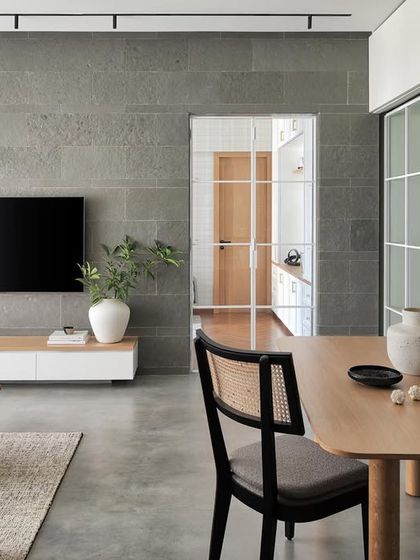 The dining space in the Zen House features an exquisitely crafted oak table with stylish cane and black-grain chairs. Sliding doors allow for a seamless transition into the study room.