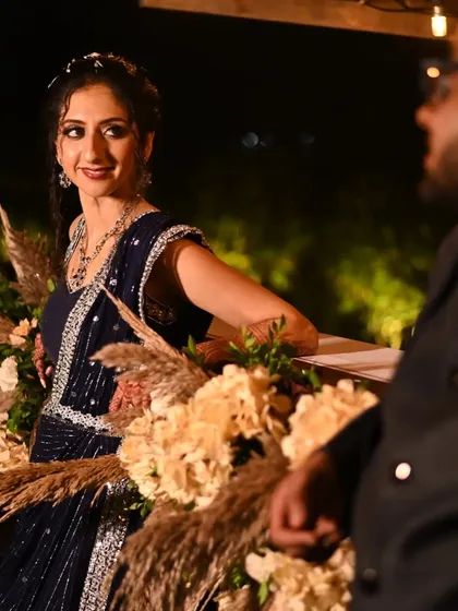 A romantic moment during the reception. The bride's elegant updo and glowing makeup look stunning against the softly lit floral decor, creating a picture perfect memory.