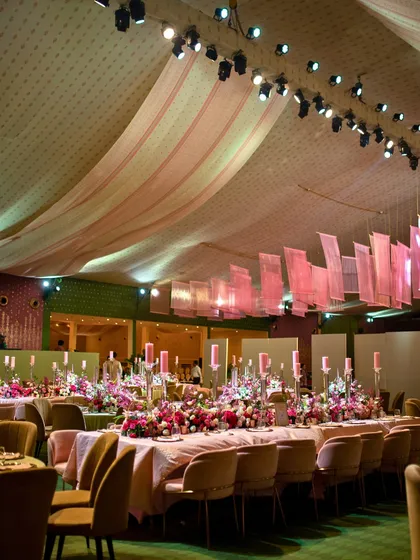 For this reception dinner, we used soft pink draping and long tables adorned with lush florals and candles. The design created a serene and inviting ambiance perfect for a relaxed family celebration.