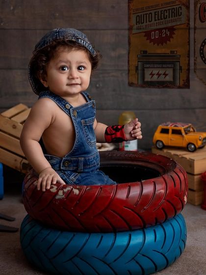 A full view of the adorable mechanic setup. The stacked tires make a perfect seat for this one year old, creating a safe and fun environment for his first birthday photoshoot.