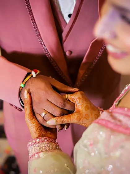 A close-up shot of a couple holding hands, focusing on the rings and the connection between them.