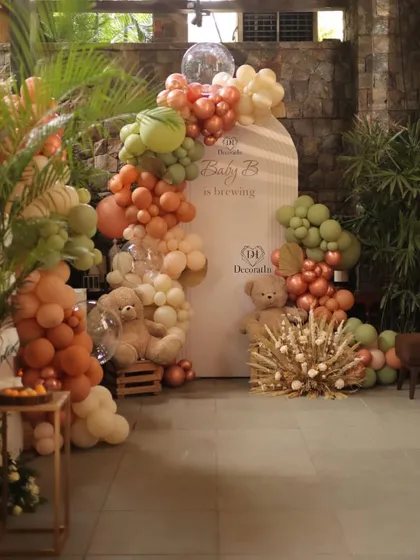 A baby shower should be as special as the parents-to-be. This "Baby is Brewing" setup features a modern, earthy palette with sage green and terracotta balloons, adorable teddy bears, and rustic pampas grass for a warm and stylish welcome.