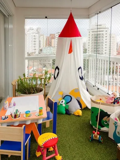 Balconies can be for kids too. I designed this safe and fun play area using soft artificial grass, a tent for imaginative play, and a child-sized table and chairs, giving the little ones their own special outdoor space.