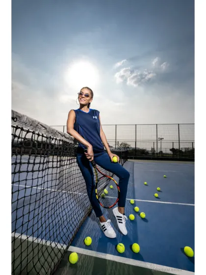 Game, set, match. A sunny, high-energy shot from the Mumbai Indians campaign, showcasing their women's sportswear line in a dynamic tennis court setting.