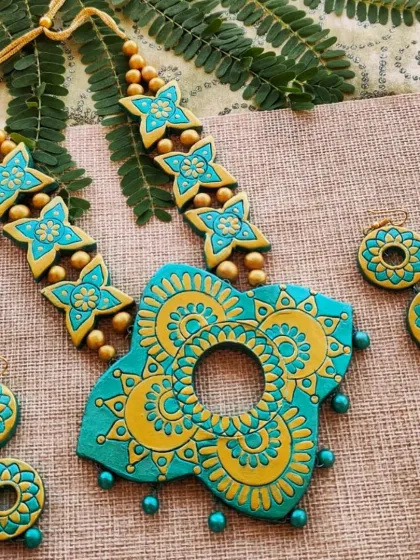 Another version of the butterfly-shaped mandala necklace, this time in a cool sea-green and gold palette. The intricate design and unique shape make it a true conversation starter.