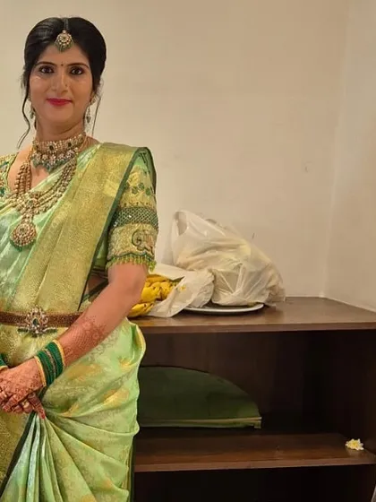 A candid shot of Vedha, her green Kanchipuram silk saree and traditional jewelry creating a timeless look.