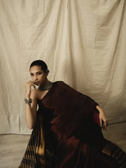 A contemplative pose from the same series, where the deep shadows and soft light create a dramatic, moody atmosphere. The focus is on the emotion and the texture of the fabric.
