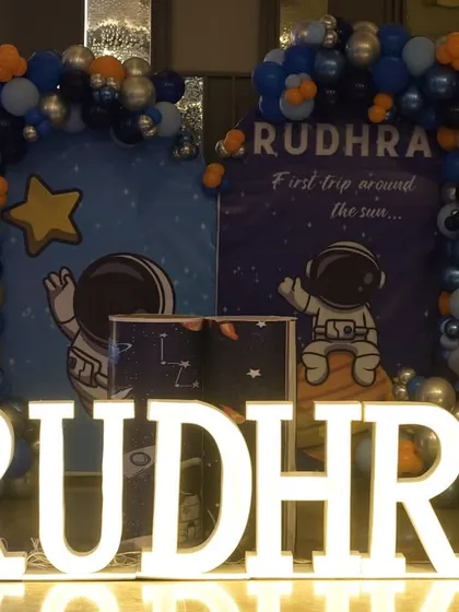 Rudhra's first trip around the sun was an out-of-this-world adventure. We designed a complete space theme with astronaut and planet cutouts, a galaxy-inspired balloon arch in shades of blue, silver, and orange, and large light-up letters, making it a stellar first birthday party.