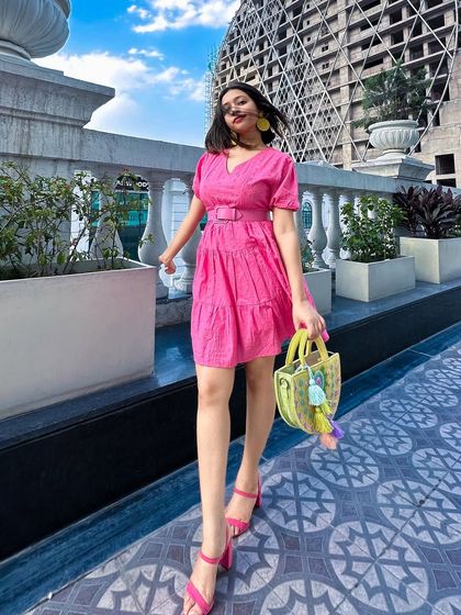 A walking shot, showing the movement of the pink dress. It's a fun and flirty piece that's perfect for a sunny day.