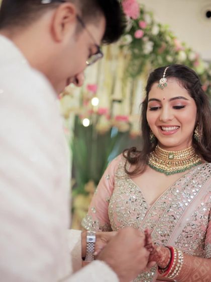 A sweet moment during the ring exchange. The bride's makeup is soft and romantic, perfect for capturing these intimate memories.