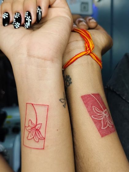 We also specialize in meaningful tattoos. This couple chose a beautiful matching floral design in red ink, a permanent symbol of their connection.
