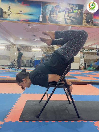 This student demonstrates great control in the chair-supported Purna Shalabhasana, engaging her core and back muscles to hold the posture.