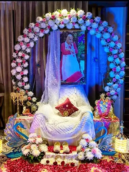 For an intimate home darbar, I created this serene setup. A beautiful circular arch of pink and white flowers frames Guru Ji's portrait, with a gracefully draped gaddi and peacock-themed props. This design shows how even a small space can be transformed into a sacred corner with detailed floral work.