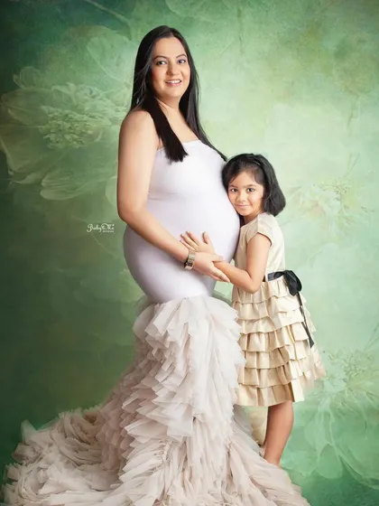 A sweet portrait of a mother and daughter, both gently holding the baby bump. These are the moments that become treasured family heirlooms.