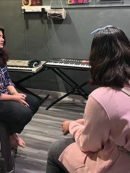 A group of students listens intently to our vocal instructor. Our group classes are a great way to learn vocal techniques in a collaborative setting.